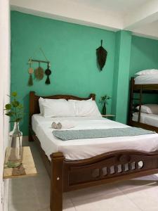 a bedroom with a bed with a green wall at Casa Guiwa Hostel in Palomino