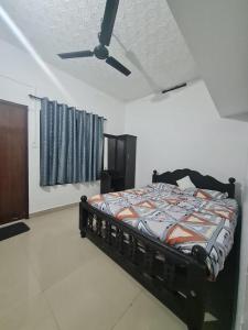 a bedroom with a bed and a ceiling fan at Mountain Manor in Vayittiri