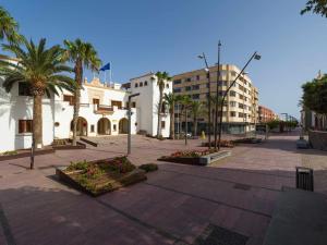 una calle de la ciudad con palmeras y edificios en Mahostly Sun and Spa en Puerto del Rosario