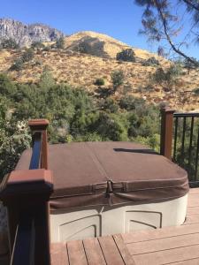 a suitcase sitting on top of a deck with a mountain at Tillie Creek Retreat: a Creekside Oasis in Wofford Heights