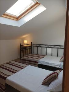 two beds in a room with a skylight at Vila Gaio in Manta Rota