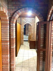 un couloir avec des arches dans un mur de briques dans l'établissement Casa Praia da Gamboa, à Garopaba