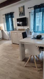uma sala de estar com uma mesa branca e cadeiras em Charmant appartement de village rénové em Gorbio