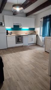 uma grande cozinha com armários brancos e piso em madeira em Charmant appartement de village rénové em Gorbio