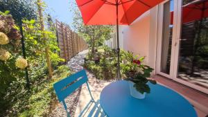 - une table avec un parasol sur le balcon dans l'établissement Les Treilles de Salies - Studio au calme, à Salies-de-Béarn