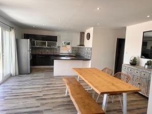 - une cuisine avec une table et des chaises en bois dans l'établissement Maison provençale au bord de l’eau, à Istres