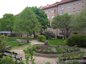 a park with benches and flowers in front of a building at Retro Apartment Praha in Prague