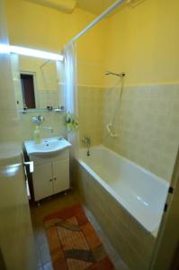 a bathroom with a white tub and a sink at Retro Apartment Praha in Prague