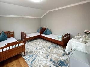 a room with three beds and a rug at Joy in Atyrau