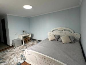 a bedroom with a white bed and a table at Joy in Atyrau +4 photos