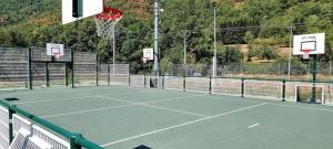einen Tennisplatz mit einem Netz und einem Basketballkorb in der Unterkunft Bergerie Ariégeoise in Ustou