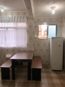 uma cozinha com uma mesa de madeira e um frigorífico em Kitnet Cantinho 26 em Mongaguá