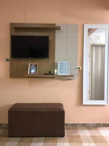 a room with a flat screen tv on a wall at Kitnet Cantinho 26 in Mongaguá