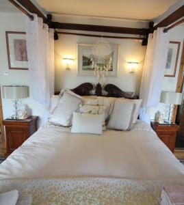 a bedroom with a large white bed with white pillows at Melorne Farm Guest House in Camelford