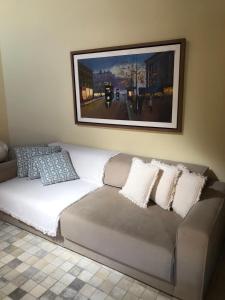 um sofá com almofadas e uma fotografia na parede em Chalé Refidim em Gravatá