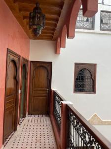 a hallway with two wooden doors and a staircase at RIAD LAICHI in Marrakech