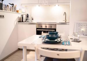 a white kitchen with a table and a stove at Modernes Apartment auf 2 Etagen in ruhiger Lage zentral zu Stadion und Westfalenhallen in Dortmund