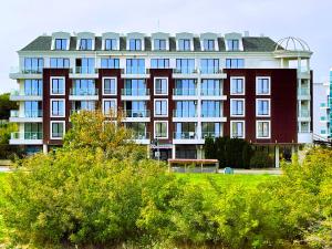 普里莫爾斯科的住宿－Apart-Hotel Panorama Sea LUX，前面有长凳的大建筑