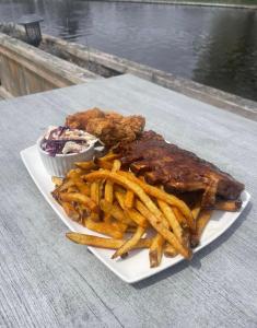 un plato de comida con costillas y papas fritas en Lagoon City Pier One Resort, en Brechin