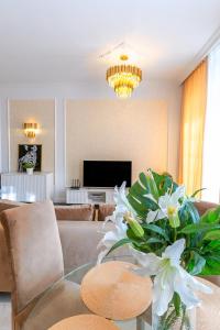 a living room with a couch and a table with flowers at Apartament Versace Jana Pawła in Wrocław