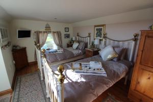 um quarto com 2 camas e um sofá em Melorne Farm Guest House em Camelford