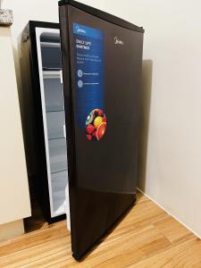 Un refrigerador negro con una bola en el costado. en JFam Suites - Studio and 1Bedroom Units!, en Biñan