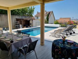 un patio con mesa, sillas y piscina en Ravissant Studio avec parking privé et jardin, en Rueil-Malmaison