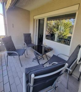 Habitación con sillas, mesa y ventana en Casa Joda en Hügelsheim