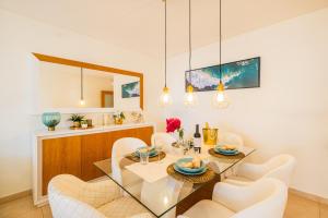 Un comedor con una mesa de cristal y sillas blancas. en Cozy villa with pool and Barbecue, en Albufeira
