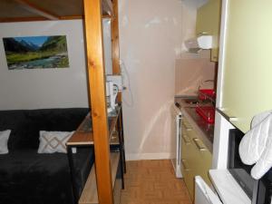 een klein appartement met een bank en een bureau in een kamer bij Appartement WIFI Monné centre Cauterets in Cauterets
