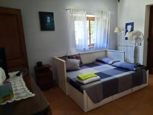 een slaapkamer met een bed met blauwe lakens en een raam bij Countryhouse Maratea coast Pollino Park in Nemoli