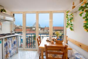 eine Küche mit einem Tisch und Stühlen sowie einen Balkon in der Unterkunft Uànema House in Neapel