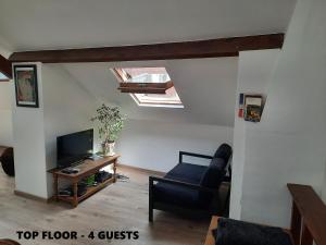 a living room with a tv and a chair at Relax Sax Appartment in Dinant