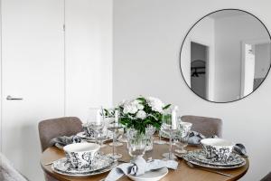 a dining room table with a mirror on the wall at Nordic city apartment by R&K Apartments in Rovaniemi