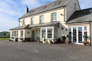 uma grande casa branca com muitas janelas em Melorne Farm Guest House em Camelford