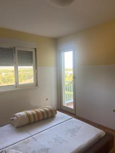 ein Schlafzimmer mit einem Bett und zwei Fenstern in der Unterkunft Pilgrim Apartments in Međugorje
