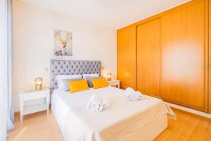 Un dormitorio con una gran cama blanca con toallas. en Cozy villa with pool and Barbecue, en Albufeira 28 fotos más