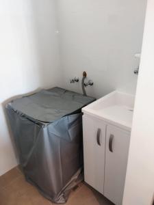 uma casa de banho com um caixote do lixo ao lado de um lavatório em Distrito 90 em Barranquilla