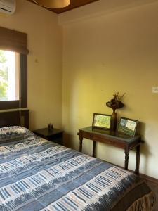 een slaapkamer met een bed en een tafel met een vaas erop bij Evie's House Arakapas in Arakapas