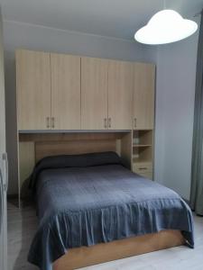 Schlafzimmer mit einem Bett mit Holzschränken in der Unterkunft sant'orsola holiday home in Misterbianco