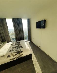 ロンドンにあるLuxurious 3 Bedroom Flat Close To East Croydon Station - Gym - Sleeps 6のベッドルーム(ベッド1台、薄型テレビ付)