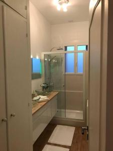 uma casa de banho com uma cabina de duche em vidro e um lavatório. em Maison 8 P. Bien situé. Entrée et sortie facile. em Ruelle-sur-Touvre