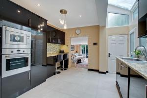 a kitchen with stainless steel appliances and a living room at Noel Road in London