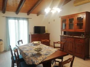 una sala da pranzo con tavolo e TV di sant'orsola holiday home a Misterbianco