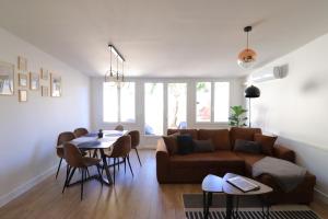 a living room with a couch and a table and chairs at Le Patio - Spacieux et lumineux T3 - 15 min centre pieds in Bergerac