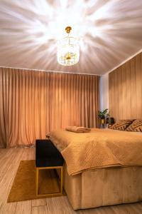 a bedroom with a large bed and a chandelier at Apartament Versace Księcia Witolda in Wrocław