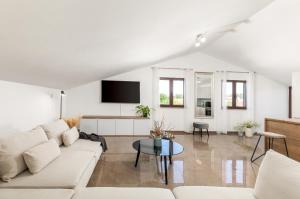 Villa Miromar في بولا: غرفة معيشة بيضاء مع أريكة وطاولة