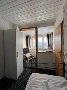 een slaapkamer met een bed, een stoel en een raam bij Ganze Pension Cecilie für Gruppenreisen in Hahnenklee-Bockswiese