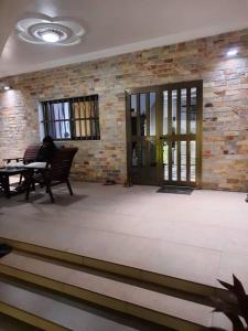 a person sitting at a table in a room with a brick wall at Villa AV Lomé in Lomé