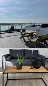 a living room with a couch and a table at PANORAMA - Exklusives Apartment an der Promenade mit Dachterrasse & Rheinblick in Emmerich